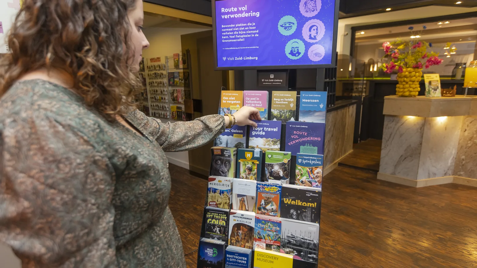 Gast bekijkt de folderdisplay met digitaal scherm